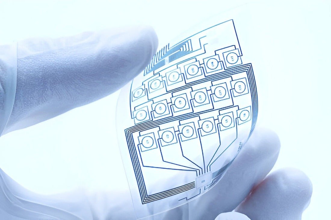 Transparent flexible PCB held in a gloved hand